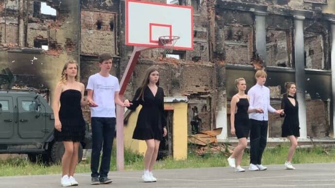 Sombre waltz of Kharkiv high school graduates in front of their school's ruins