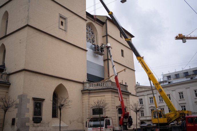 Монтажери встановлюють захисні екрани на вітражі на Латинській катедрі в центрі Львова