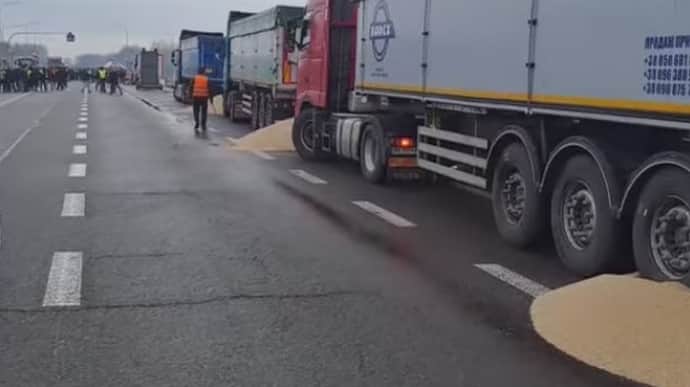 Polish farmers spill grain from Ukrainian trucks on border – video