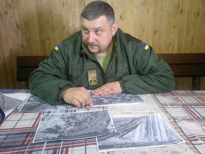 Комбат Олег Громадський демонструє фото аеророзвідки. З них видно, що позиції супротивника облаштовували ті, хто має досвід чеченської війни