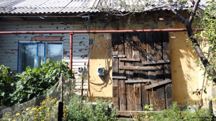 Вікно кімнати, в який лежить інвалід Олександр. Родичі заклали вікно шпалами, оскільки він не в змозі ховатися в підвалі