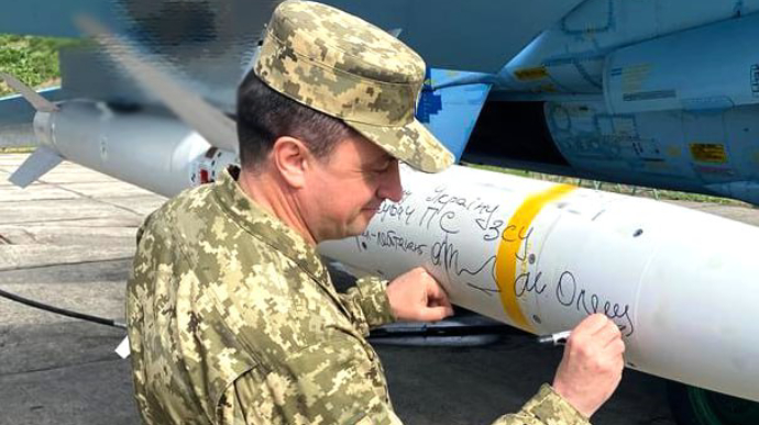 Air Force Commander signs HARM missile: message partially censored