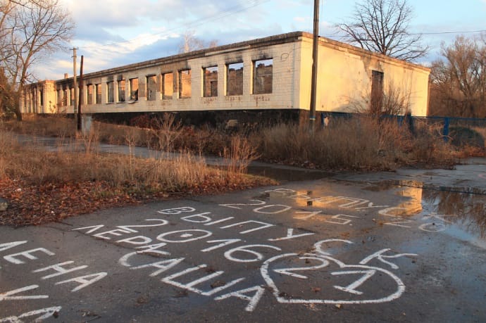 Хоча школа згоріла ще в 2014-му, на асфальті поруч біліють написи 