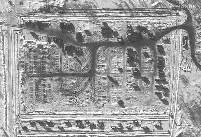 Группа грузовых автомобилей и военной техники оставляют полигон в Ельне, РФ. Снимок 13 февраля.